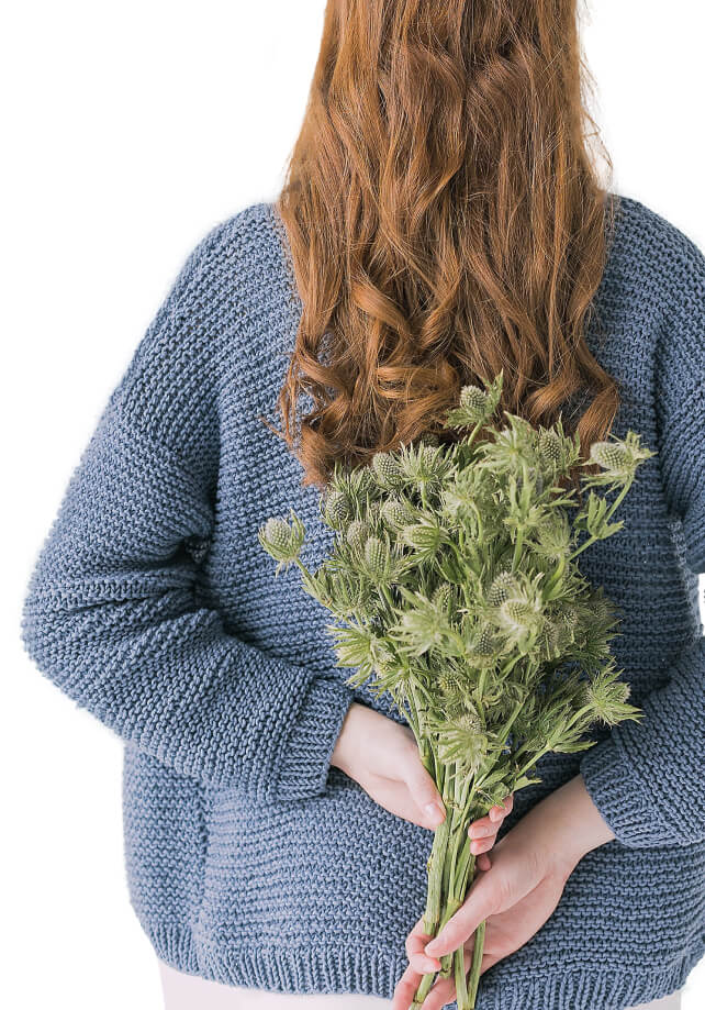 Elena Joy facing backwards, holding flowers behind her back